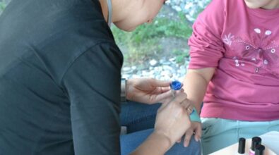 Na zdjęciu animator robi tatuaż na ręku dziecka.