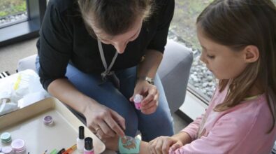 Na zdjęciu animator robi tatuaż na ręku dziecka.