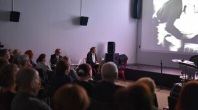 Sala kinowa. Przed ekranem mężczyźni grający na instrumentach.