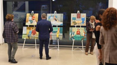 Uczestnicy wystawy oglądają obrazy.