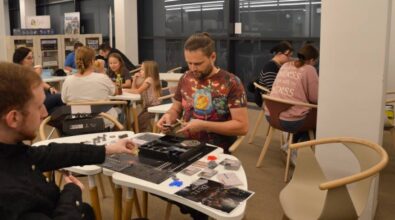 Widok na osoby siedzące przy stolikach i grające w gry planszowe.